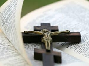 wooden cross on top of an open bible